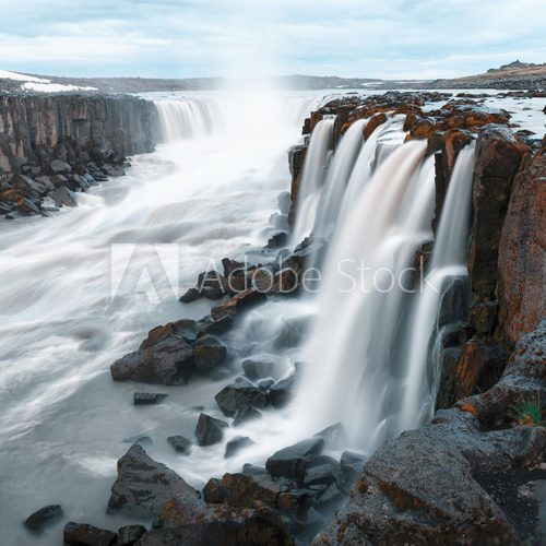 Cascade furieuse sous ciel tourmenté