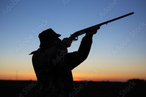 Silhouette d'un chasseur au coucher du soleil